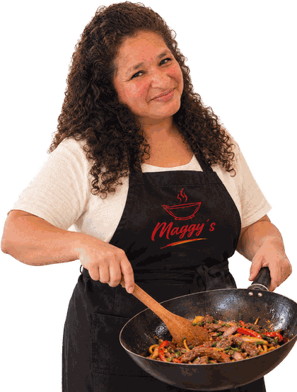 Magaly con el delantal de Maggy’s, salteando un lomo en el wok con cuchara de madera.